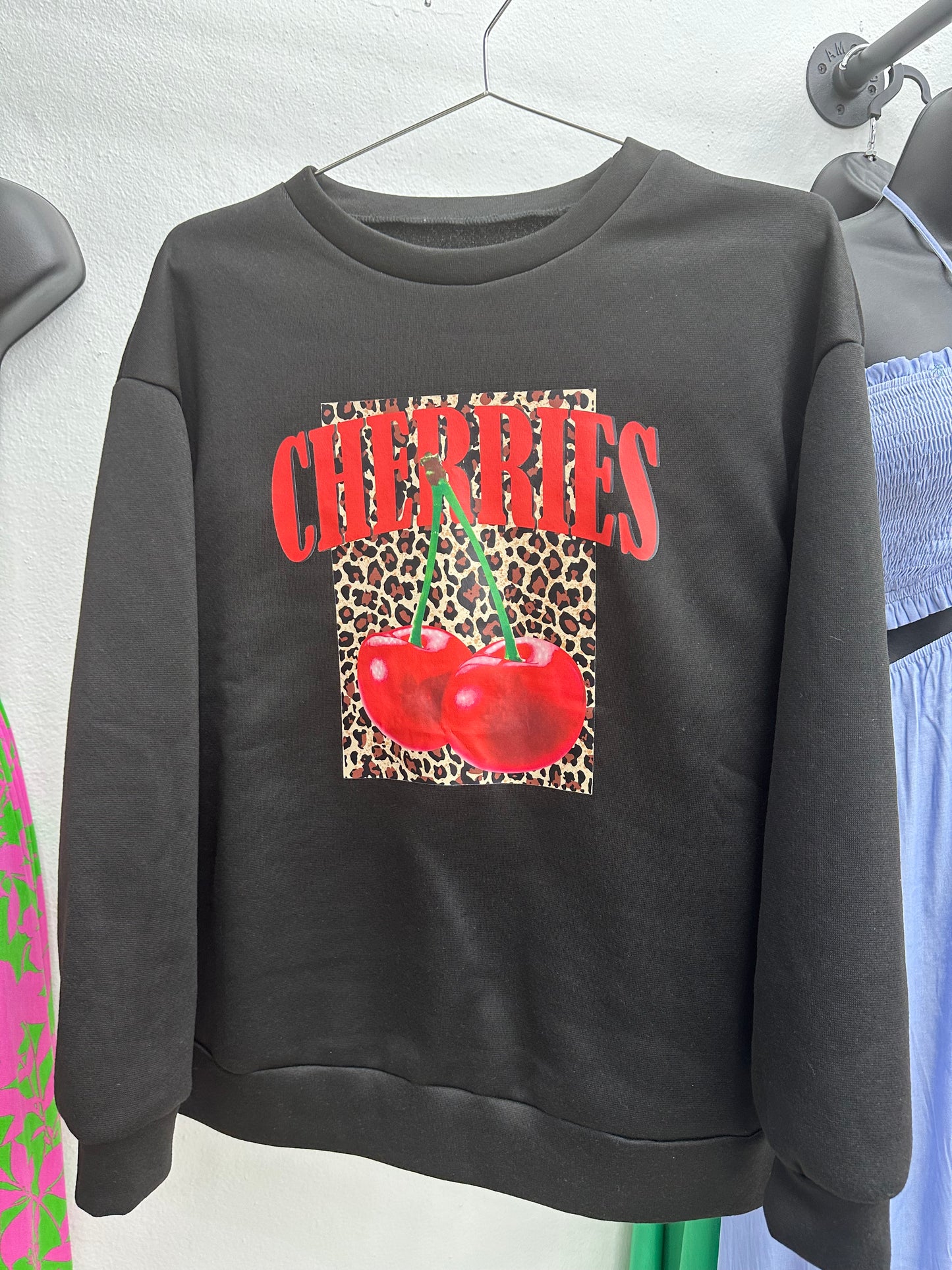 Sudadera negra, de cherries y animal print.