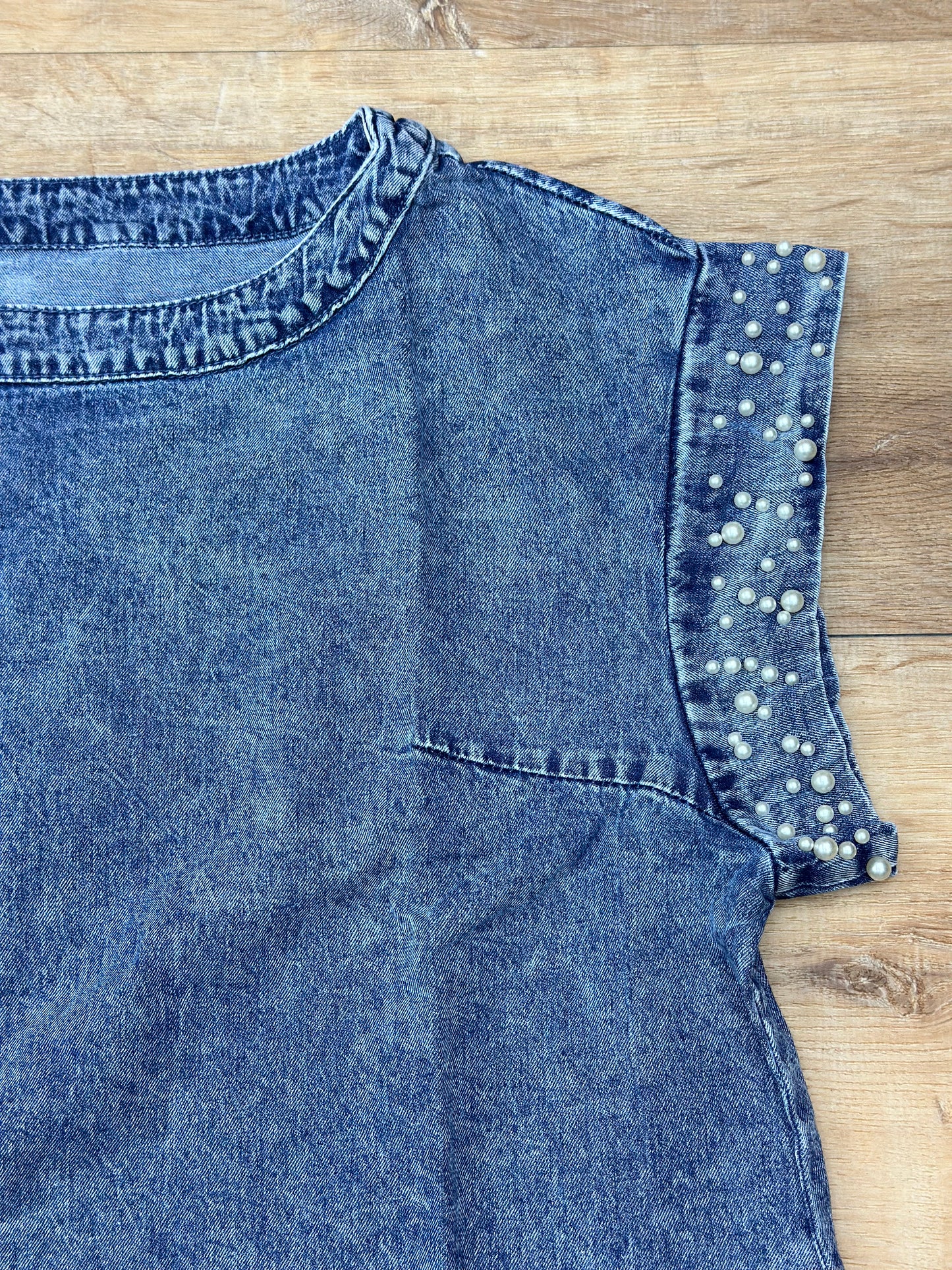 Blusa denim de vestir con perlas en sus mangas.